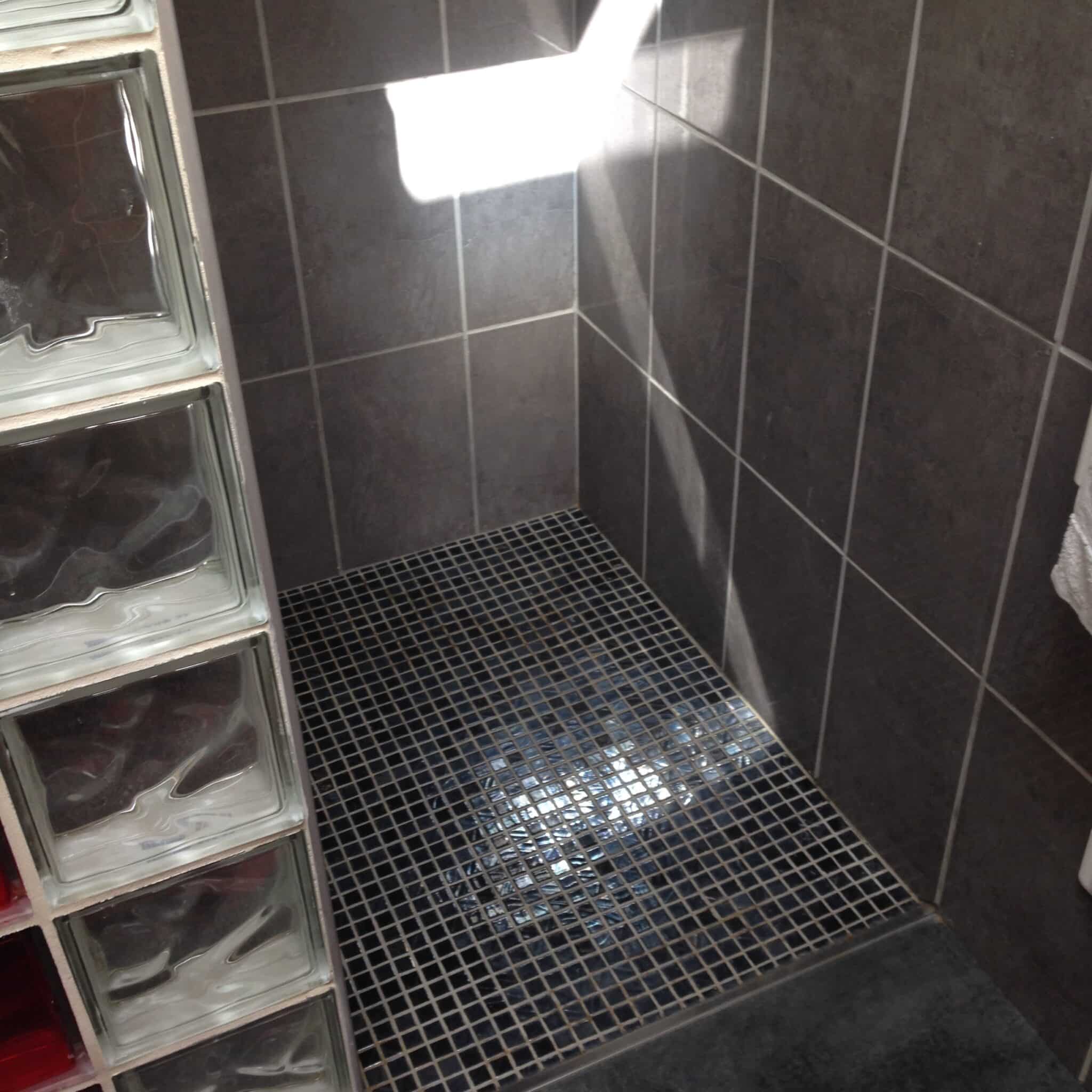 Douche carrelée en noir avec receveur assorti