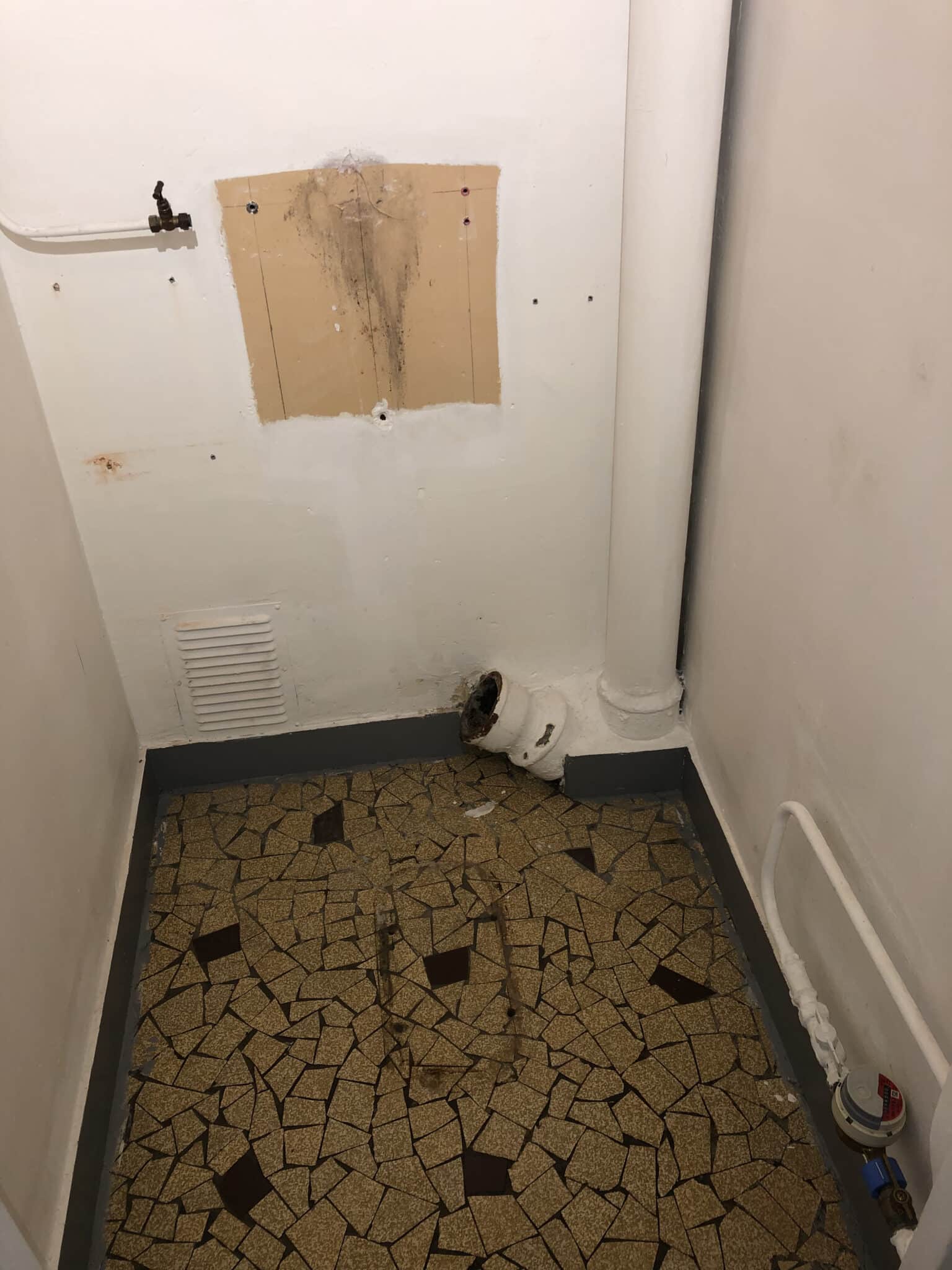 Mur brut avec arrivée d’eau et sol en cours de rénovation