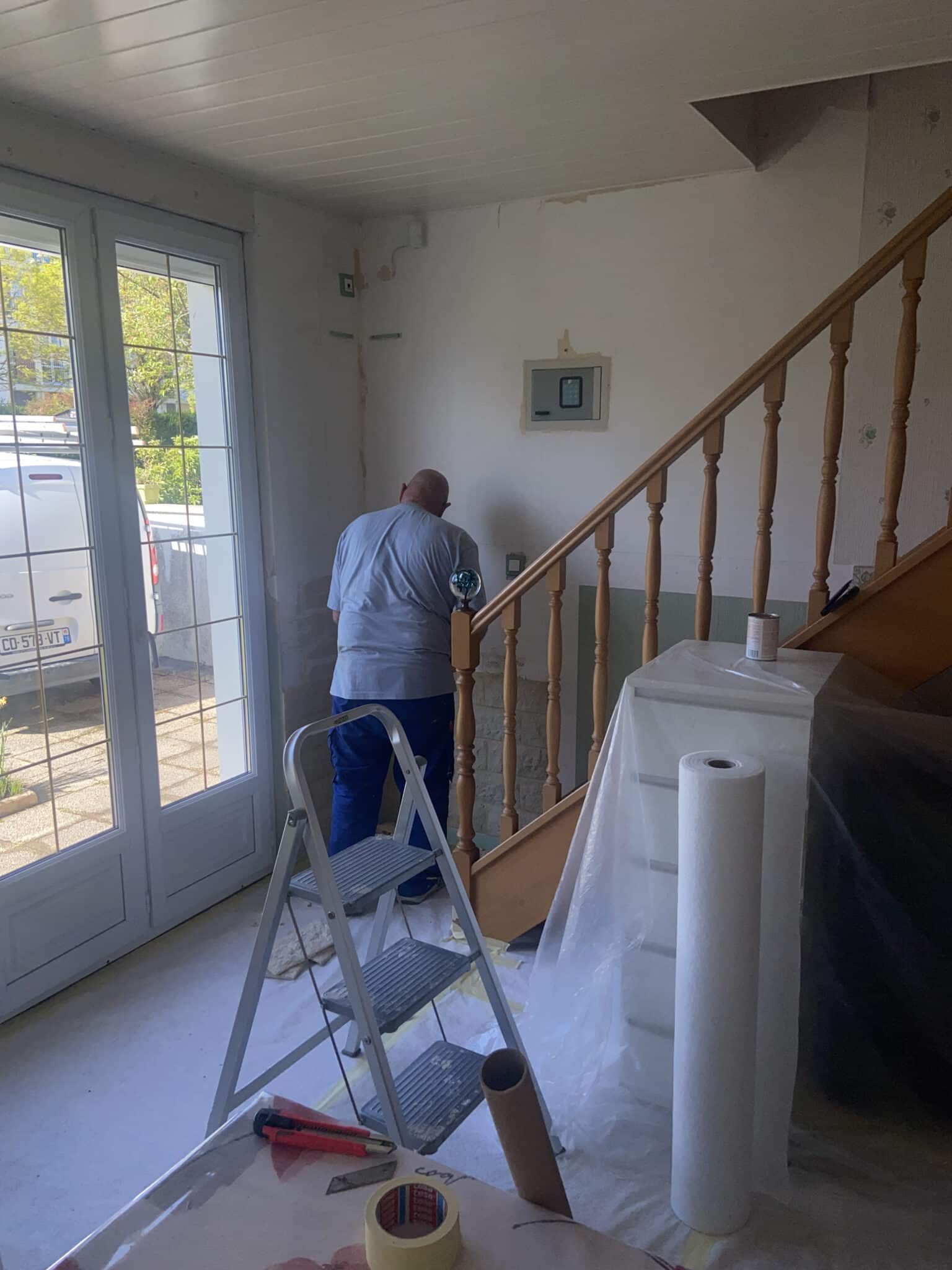 Salon en rénovation avec artisan sur escabeau